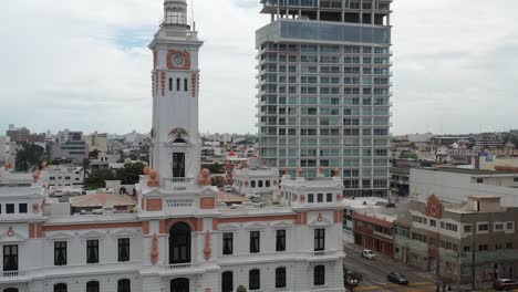 A-clock-tower,-Faro-Venustiano-Carranza-stands-as-a-historic-marker-beside-modern-high-rises-in-a-Veracruz,-Mexico
