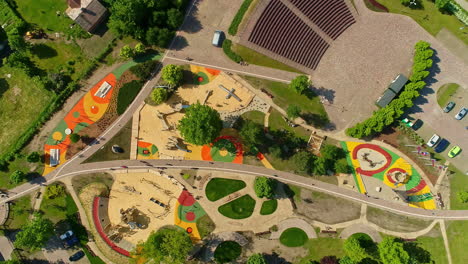 Aerial-view-of-the-colorful-Uzvaras-parks,-with-playground-and-green-trees-in-Jelgava,-Latvia