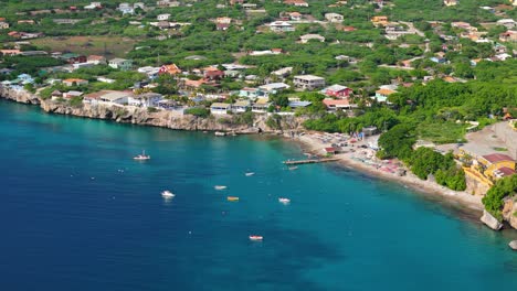 Descripción-Aérea-De-Playa-Piskado-Mientras-Los-Barcos-Y-Nadadores-Disfrutan-Del-Agua-Caribeña-De-Curazao.