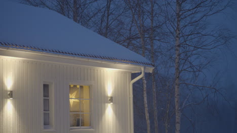 An-Einem-Verschneiten,-Ruhigen-Abend-Leuchten-Weihnachtslichter-Durch-Das-Fenster