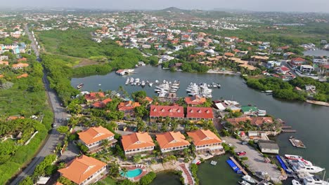 Aerial-orbit-around-Spanish-water-boat-docks-and-houses-at-midday,-Curacao