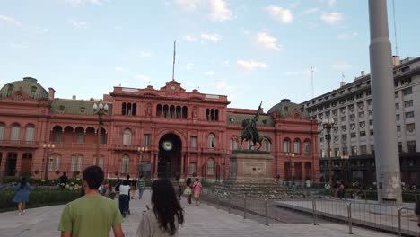 Los-Turistas-Caminan-En-La-Plaza-De-Mayo,-La-Famosa-Plaza-Argentina-Y-El-Edificio-Presidencial-De-La-Casa-Rosa.
