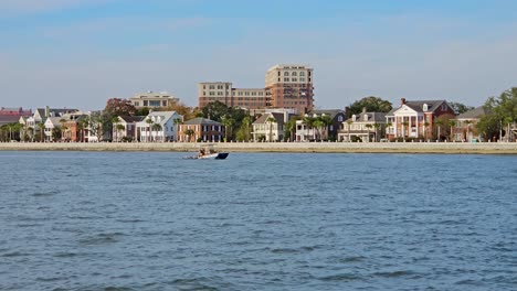 Crab-boat-surrounded-by-pelicans-with-Charleston-city-coastline-in-the-background