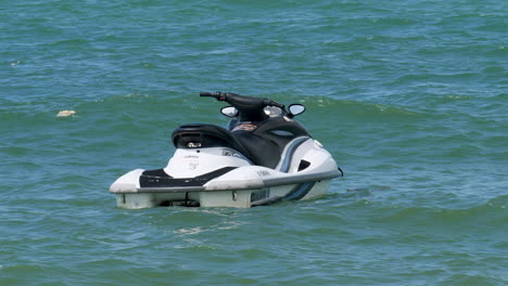 Jet-ski-anchored-at-the-beachfront-of-Pattaya-is-rocking-with-the-waves,-in-the-province-of-Chonburi,-Thailand