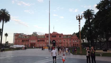 Los-Turistas-Caminan-Por-El-Centro-De-La-Ciudad-De-Buenos-Aires,-Plaza-De-Mayo,-Casa-Rosada-En-El-Horizonte-De-Verano,-Argentina.