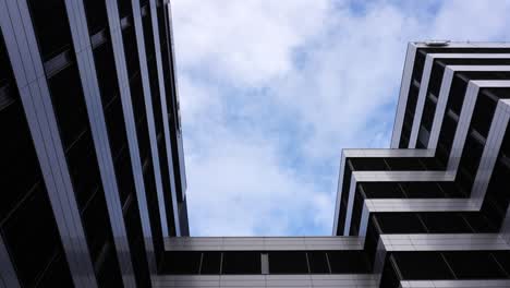 Statische-Aufnahme-Der-Außenseite-Eines-Modernen-Bürogebäudes,-Während-Sich-Weiße-Wolken-Bewegen