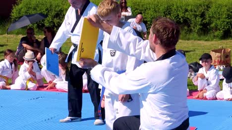 Taekwondo-Student-is-Trying-to-Take-New-Belt-Under-Taekwondo-Belt-Testing