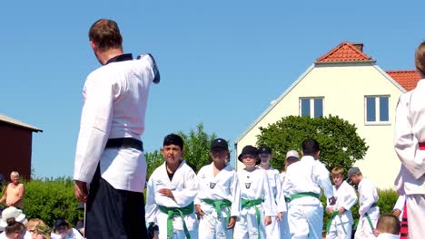 Taekwondo-Lehrer-Mit-Schwarzem-Gürtel-Bringen-Schülern-Mit-Grünem-Gürtel-Bei,-In-Richtung-Des-Kopfes-Des-Gegners-Zu-Treten