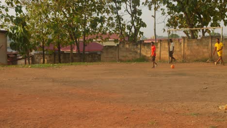 Goal-keeper-kicks-the-ball-to-another-player-to-start-the-game-at-a-community-football-pitch-in-Kumasi,-Ghana