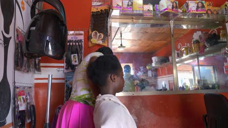 Hairdresser-blowing-drying-customer’s-hair-in-busy-Kumasi-salon-in-Ghana
