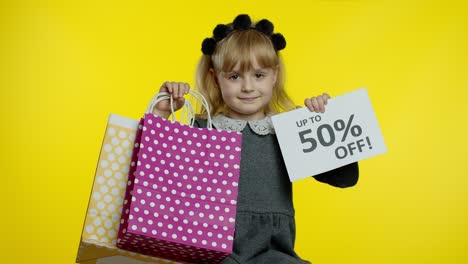 Child-girl-showing-Up-To-50-percent-Off-inscription-sign-and-shopping-bags.-Teen-pupil-smiling
