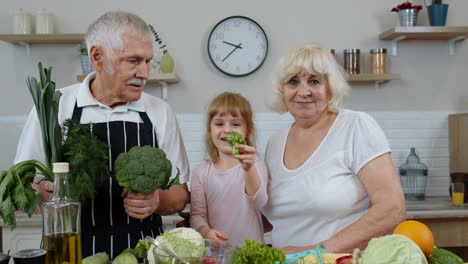 Girl-with-mature-man-and-woman-recommending-eating-raw-vegetable-food.-Healthy-nutrition-diet
