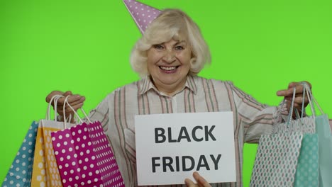 Inscription-advertising-Black-Friday-appears-next-to-joyful-grandmother-with-shopping-bags