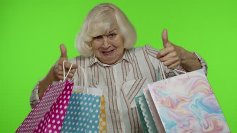Grandmother-holding-shopping-bags,-rejoicing-discounts-in-store,-enjoying-shopping-with-low-prices