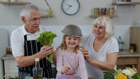 Ältere-Frau-Und-Mann-Mit-Enkelkind,-Die-Zu-Hause-Mit-Sieb-Und-Gemüse-Herumalbern