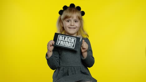 Child-girl-showing-Black-Friday-inscription,-smiling,-looking-satisfied-with-low-prices,-discounts