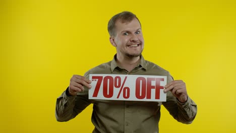 Smiling-man-showing-Up-To-70-percent-Off-inscriptions-signs,-rejoicing-good-discounts,-low-prices