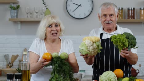Senior-grandparents-couple-in-kitchen.-Mature-man-and-woman-recommending-eating-raw-vegetable-food