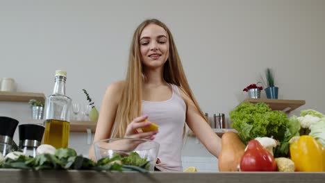 Chica-Vegana-Cocinando-Ensalada-Con-Verduras-Crudas,-Añadiendo-Jugo-De-Limón.-Exprimir-Una-Fruta-De-Limón-En-Las-Manos