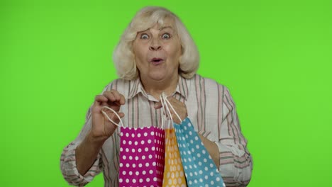 Ältere-Großmutter-Zeigt-Die-Werbeaufschrift-„Sale-Prozent-Rabatt“-Aus-Der-Einkaufstasche