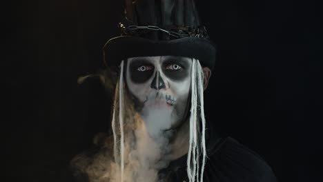 Erschreckender-Mann-Im-Gruseligen-Skelett-Halloween-Cosplay,-Der-Zigarettenrauch-Aus-Seinem-Mund-Ausatmet