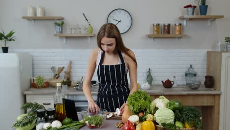 Chica-Vegana-Cocinando-Ensalada-Con-Verduras-Crudas-Mientras-Mira-Una-Tableta-Digital-Para-Obtener-Una-Receta-En-Línea