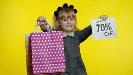 Child-girl-showing-Up-To-70-percent-Off-inscription-sign-and-shopping-bags.-Teen-pupil-smiling