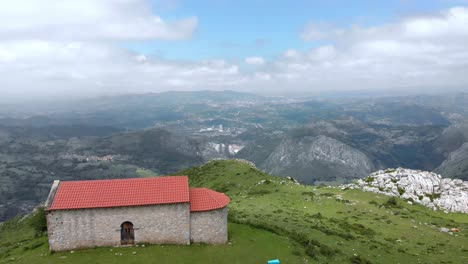 Kühe-Grasen-Am-Rande-Der-Monsacro-Bergkapelle,-Asturien-Luftlandschaft-Drohnen-Panoramaaufnahme