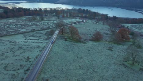 Quiet-road-leading-to-lake-on-frosty-autumn-morning