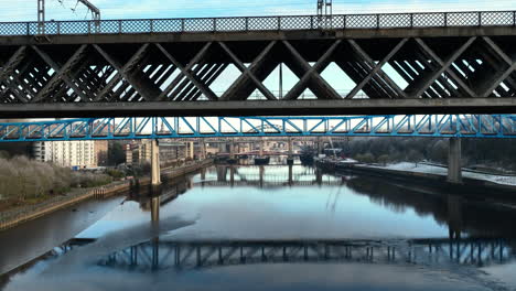 Vogel-Fliegt-An-Wunderschönen-Luftaufnahmen-Von-Brücken-Und-Reflexionen-Auf-Dem-Fluss-Tyne,-Newcastle-Vorbei