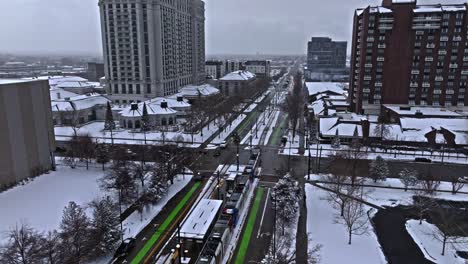 TRAX-light-rail-system-in-a-snowy-downtown-Salt-Lake-City,-aerial-view