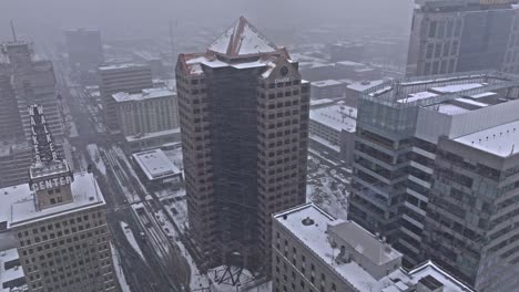 High-angle-drone-view-of-One-Utah-Center-in-Salt-Lake-City-as-winter-snow-falls