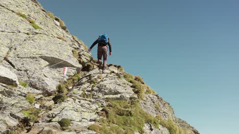 Hiker-walking-and-climbing-Cima-Fontana-mountain-of-Valmalenco-in-summer-season,-Italy