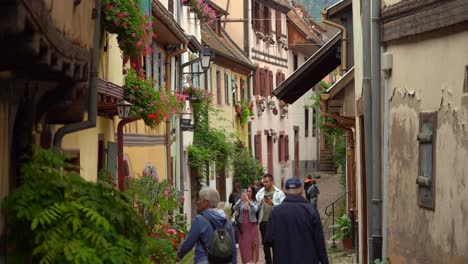 People-Stroll-through-the-cobblestone-streets-of-Eguisheim,-one-of-the-Most-Beautiful-Villages-in-France---Eguisheim