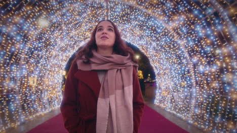 girl-walks-through-a-beautiful-tunnel-of-Christmas-lights-slow-motion-wide-shot