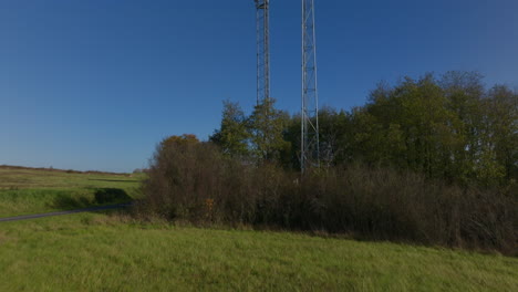 Two-brand-new-5G-cellular-towers-in-France-countryside,-aerial-dolly-up-tilting-reveal