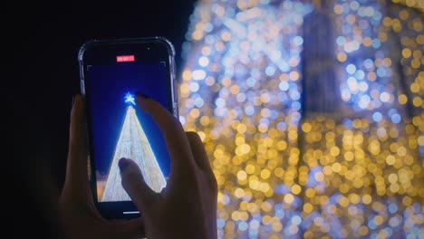 Das-Mädchen-Nimmt-Mit-Ihrem-Smartphone-Ein-Video-Der-Weihnachtsbeleuchtung-In-Zeitlupe-Aus-Nächster-Nähe-Auf