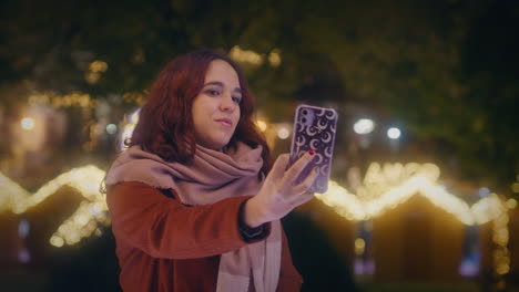 Mädchen-Macht-Mit-Ihrem-Smartphone-Ein-Selfie-Auf-Einem-Weihnachtsmarkt-In-Zeitlupe