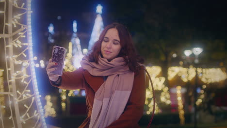 Mädchen-Macht-Mit-Ihrem-Smartphone-Ein-Selfie-Auf-Einem-Weihnachtsmarkt,-Mittlere-Zeitlupenaufnahme-Mit-Gimbal