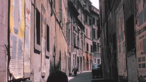 Man-on-a-Bicycle-on-a-Narrow-Street-in-the-City-of-Rome-in-1960s-Sunny-Day
