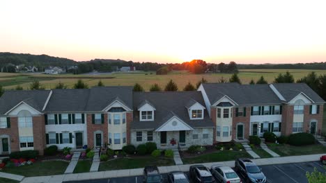 Sunset-over-a-uniform-suburban-townhouse-complex-with-parked-cars