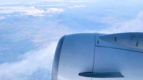 Motoransicht-Aus-Dem-Flugzeugfenster,-Wolkengebilde-Und-Blauer-Himmel,-Große-Höhe