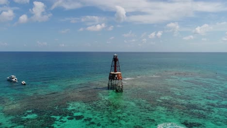 A-4K-drone-shot-of-an-abandoned-lighthouse,-in-a-remote-area-of-the-Caribbean-Sea,-near-Bimini,-Bahamas