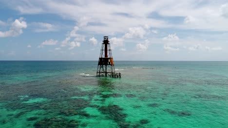 A-4K-drone-shot-of-an-abandoned-lighthouse,-in-a-remote-area-of-the-Caribbean-Sea,-near-Bimini,-Bahamas