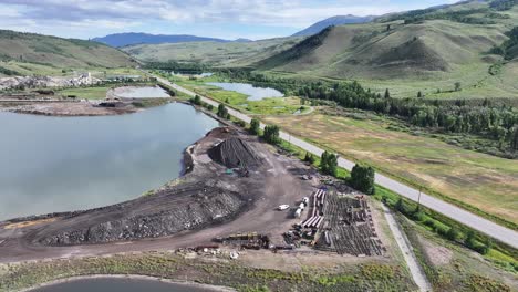 large-operational-gravel-producing-facility-in-Silverthorne-colorado-near-a-lake-on-a-sunny-day-AERIAL-PAN