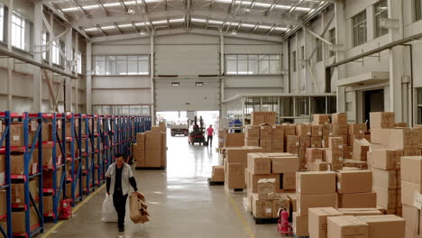 People-are-woking-at-a-busy-Chinese-factory-warehouse-filled-with-labeled-cardboard-boxes