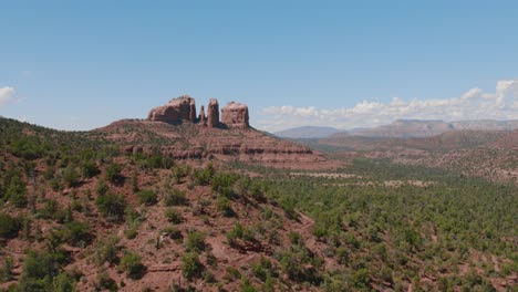 An-aerial-reveal-for-the-beautiful-landscape-of-Sedona,-Arizona-in-the-spring-surrounded-by-mountains-on-a-clear-day