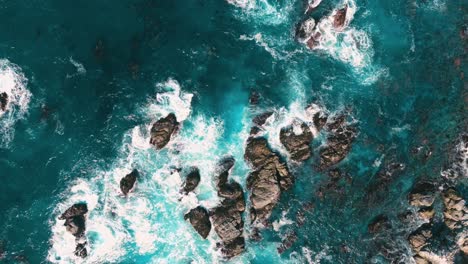 Top-down-view-rock-cliff-seaside-coast-in-super-slow-motion-in-California