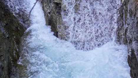 Slow-motion-shot-of-water-falling-from-height-creating-a-beautiful-waterfall-in-Badgastein,-Austria-at-daytime