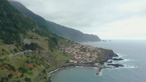 Küste-Von-Seixal,-Madeira,-Mit-Wellen,-Bergen-In-Wolken,-Panoramablick-Auf-Das-Meer,-Horizont-Mit-Klippen,-Panoramahimmel,-Hebende-Drohnenaufnahme